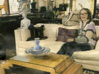 Karen Johnson Boyd sitting on a sofa surrounded by artwork