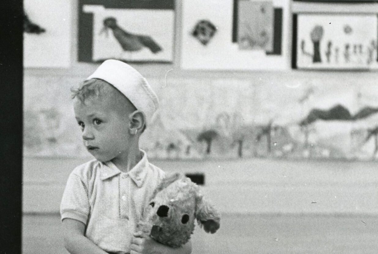 Black and white photo of a child with a stuffed animal