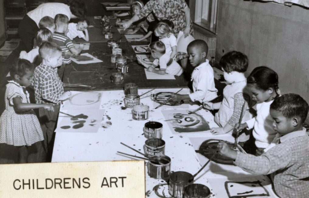 A black and white photo of a children's painting class