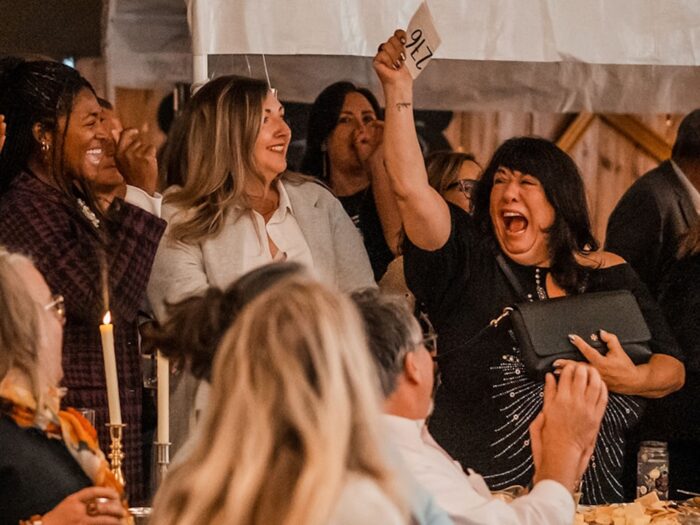 woman celebrating winning an auction at a RAM event