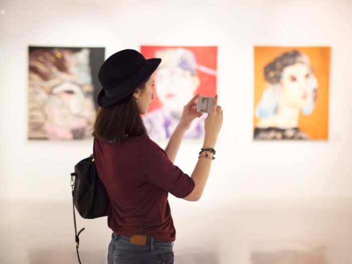 A woman taking photos of art at RAM